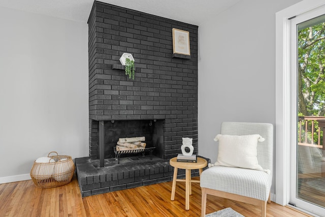 1805 Melrose Ave, Saint Louis Park, MN 55426 - sitting room with wood finished floors, a brick fireplace, and baseboards