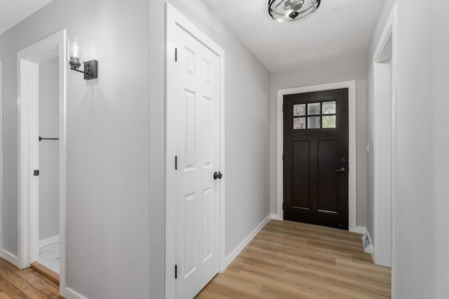 1805 Melrose Ave, Saint Louis Park, MN 55426 - doorway featuring light wood-type flooring, baseboards, and a textured ceiling