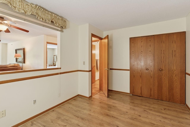 32 11th Ave S Unit 204, Hopkins, MN 55343 - unfurnished bedroom with wood finished floors, baseboards, a closet, and ceiling fan
