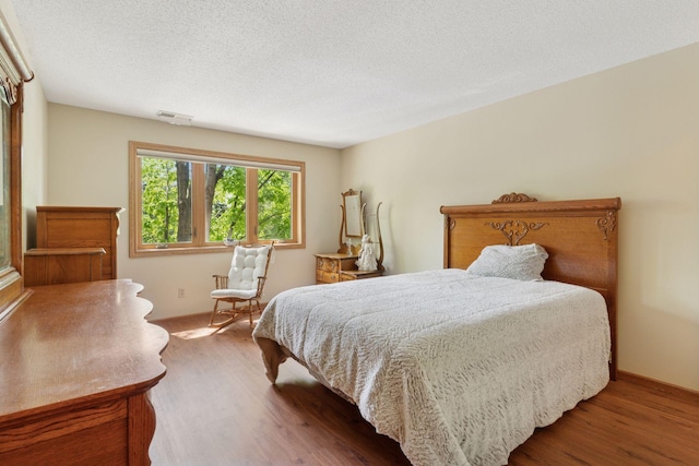 32 11th Ave S Unit 204, Hopkins, MN 55343 - bedroom featuring wood finished floors, baseboards, and a textured ceiling