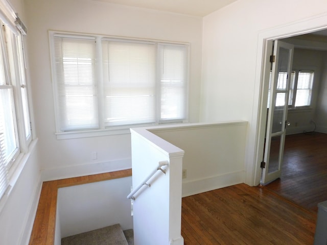stairway with wood finished floors and baseboards