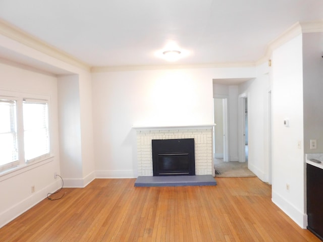 unfurnished living room with light wood-type flooring, a fireplace, and baseboards