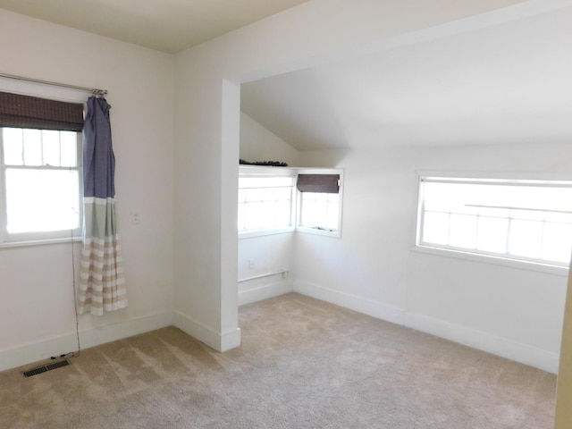 unfurnished room with carpet, vaulted ceiling, and baseboards