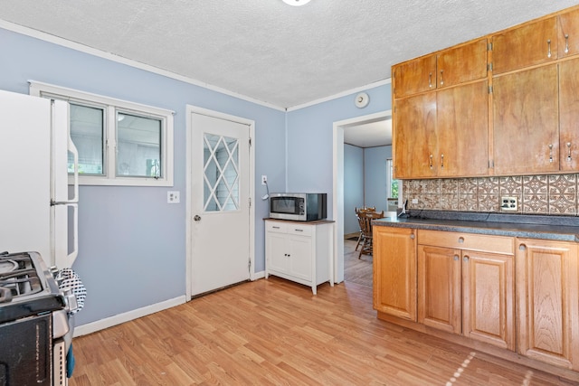 37726 2nd Ave, Dennison, MN 55018 - kitchen featuring stainless steel microwave, freestanding refrigerator, gas stove, tasteful backsplash, and dark countertops