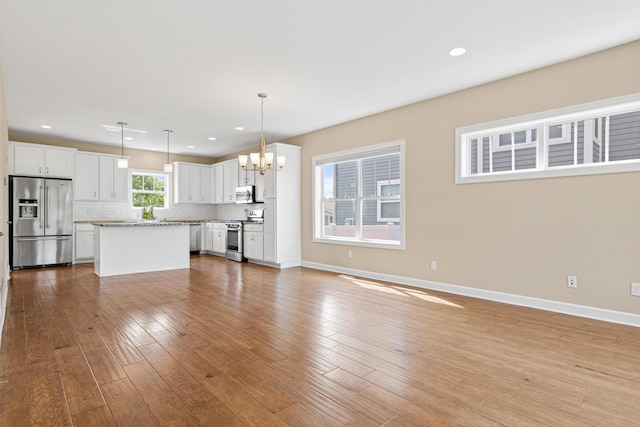5024 Humboldt Ln N, Minneapolis, MN 55430 - unfurnished living room featuring a chandelier, baseboards, light wood finished floors, and recessed lighting