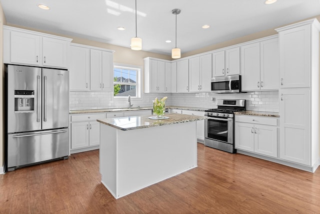 5024 Humboldt Ln N, Minneapolis, MN 55430 - kitchen featuring appliances with stainless steel finishes, white cabinets, light wood-style floors, decorative backsplash, and recessed lighting