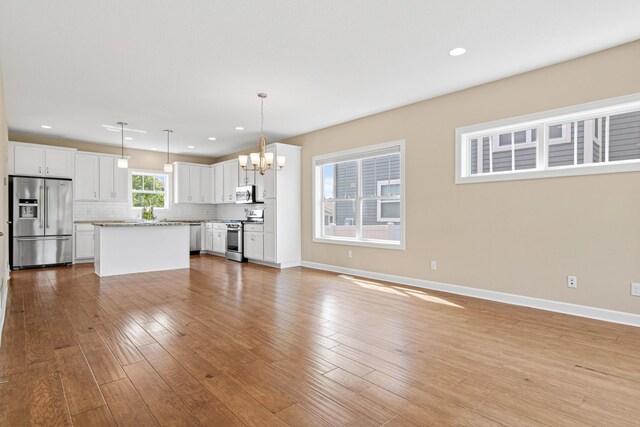 5024 Humboldt Ln N, Minneapolis, MN 55430 - unfurnished living room with a chandelier, baseboards, light wood-type flooring, and recessed lighting