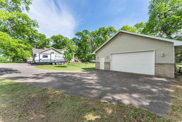 2308 Crosstown Blvd NE, Ham Lake, MN 55304 - view of side of home featuring brick siding, a garage, an outbuilding, and a lawn