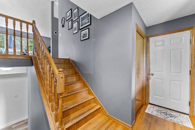 2308 Crosstown Blvd NE, Ham Lake, MN 55304 - stairway featuring wood finished floors, baseboards, and a textured ceiling