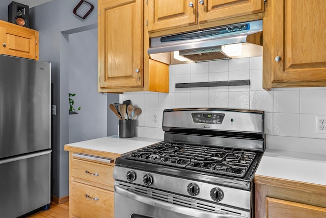 2308 Crosstown Blvd NE, Ham Lake, MN 55304 - kitchen with appliances with stainless steel finishes, under cabinet range hood, light countertops, tasteful backsplash, and light wood-style floors