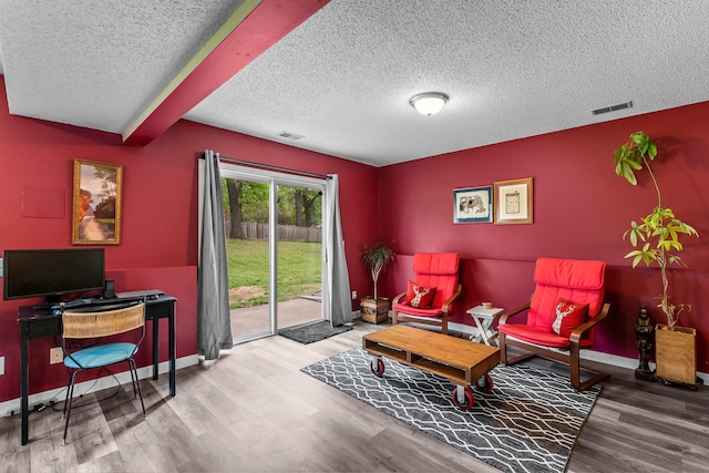 2308 Crosstown Blvd NE, Ham Lake, MN 55304 - living area featuring a textured ceiling, wood finished floors, and baseboards
