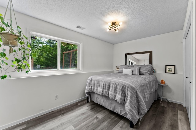 2308 Crosstown Blvd NE, Ham Lake, MN 55304 - bedroom featuring wood finished floors, a textured ceiling, and baseboards