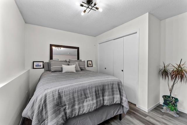 2308 Crosstown Blvd NE, Ham Lake, MN 55304 - bedroom with wood finished floors, a textured ceiling, a closet, and baseboards