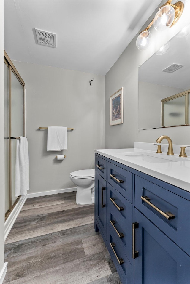 2308 Crosstown Blvd NE, Ham Lake, MN 55304 - bathroom with a shower stall, toilet, vanity, and wood finished floors