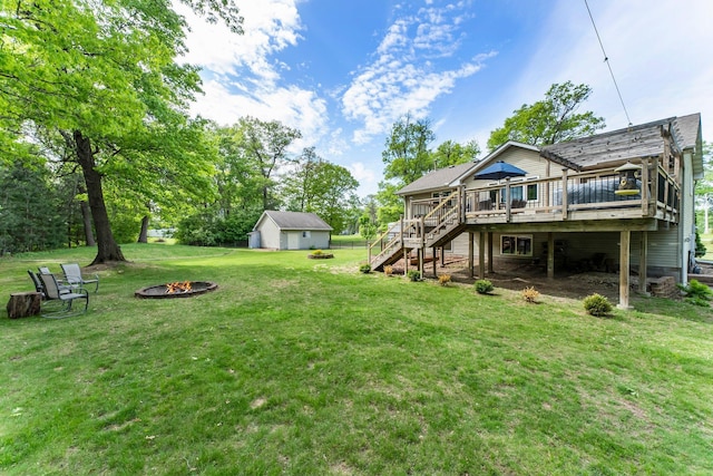 2308 Crosstown Blvd NE, Ham Lake, MN 55304 - view of grassy yard with an outdoor fire pit, stairs, a wooden deck, and an outbuilding