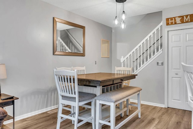 1963 Bluestem Ln, Shoreview, MN 55126 - dining space featuring light wood-type flooring, stairway, and baseboards