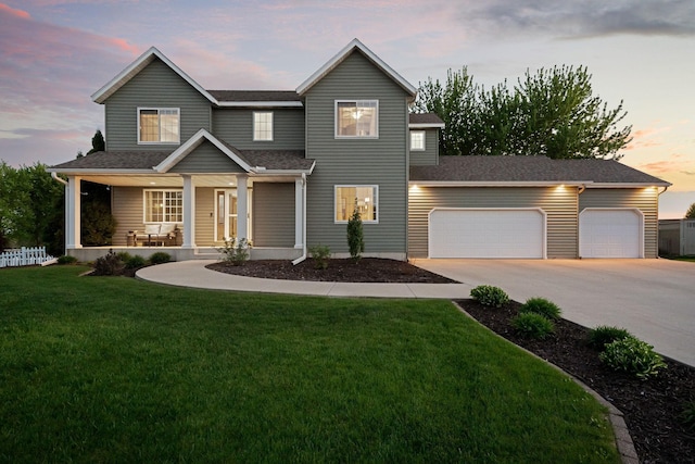 view of front of home featuring a garage, driveway, covered porch, a front lawn, and roof with shingles
