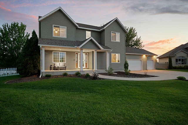 traditional home with covered porch, concrete driveway, a shingled roof, and a garage