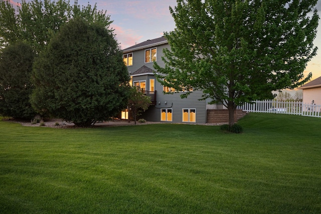 yard at dusk featuring an attached garage