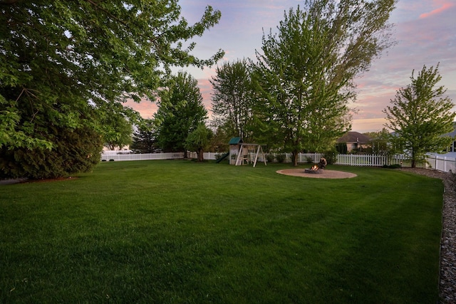 view of yard featuring a playground and an outdoor fire pit