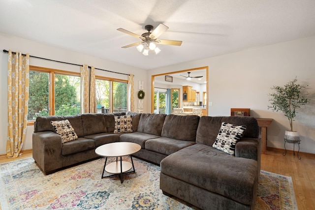 living area featuring ceiling fan, wood finished floors, and baseboards