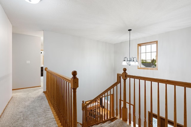 staircase featuring carpet and a chandelier