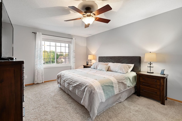 bedroom with light colored carpet, baseboards, and ceiling fan
