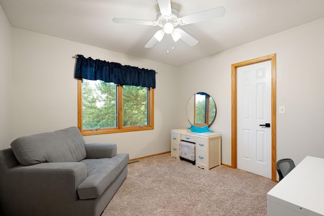 sitting room with light carpet, baseboards, and ceiling fan