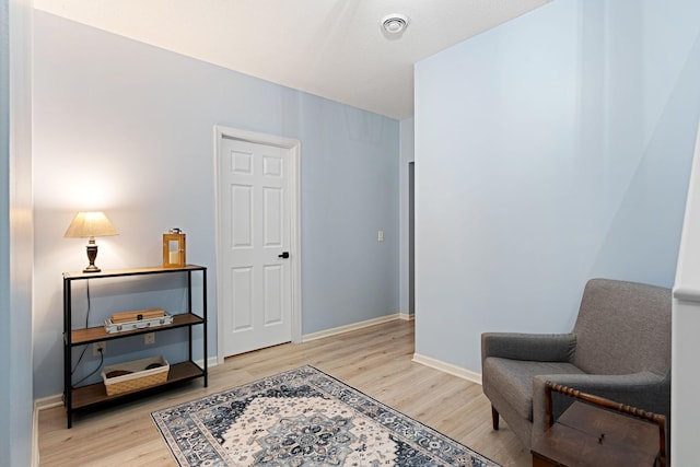 living area with light wood-style flooring and baseboards