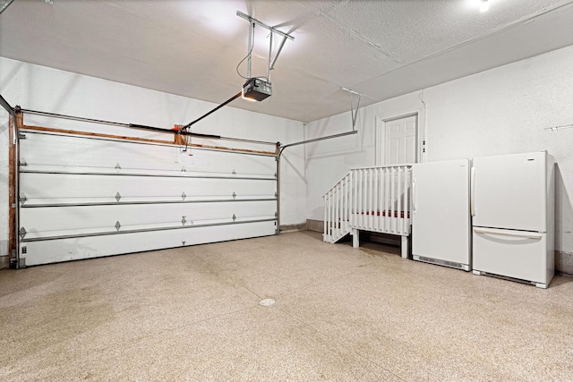 garage with freestanding refrigerator and a garage door opener