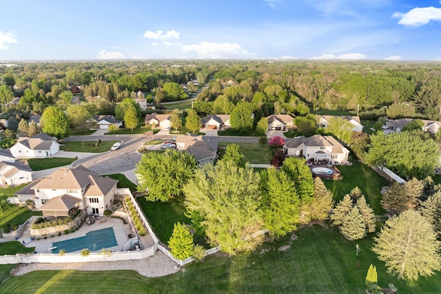 aerial view of property and surrounding area with nearby suburban area and a forest