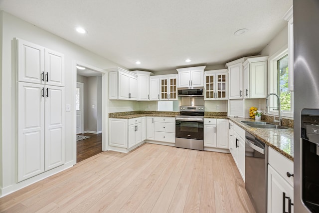 1588 Chatham Ave, Arden Hills, MN 55112 - kitchen with stainless steel appliances, a sink, light wood-type flooring, white cabinetry, and recessed lighting