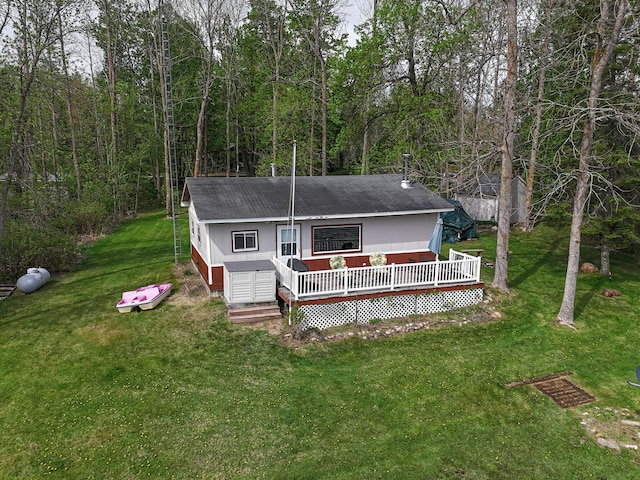 7528 Little Thunder Dr NE, Remer, MN 56672 - back of house featuring a wooden deck, a lawn, a shingled roof, and a forest view