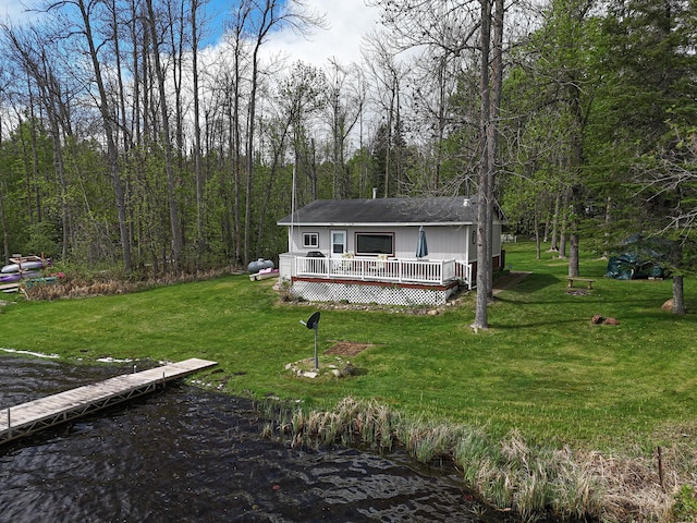 7528 Little Thunder Dr NE, Remer, MN 56672 - manufactured / mobile home with a wooden deck, a front lawn, a forest view, and roof with shingles