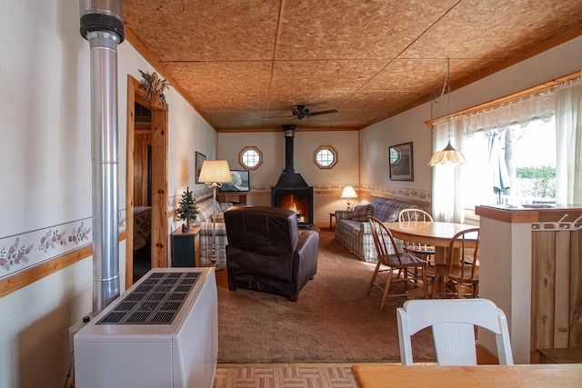 7528 Little Thunder Dr NE, Remer, MN 56672 - dining space with a wood stove, plenty of natural light, a ceiling fan, and carpet floors