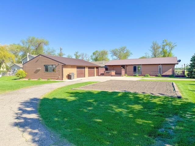 view of front of property featuring driveway, metal roof, and a front lawn