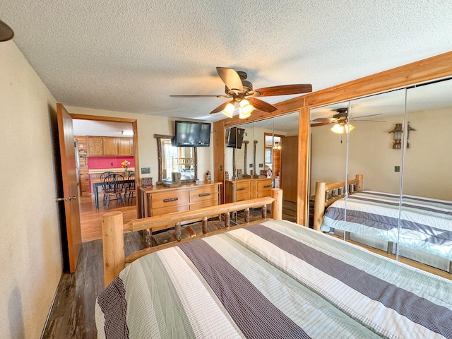 bedroom featuring wood finished floors, a textured ceiling, and a ceiling fan