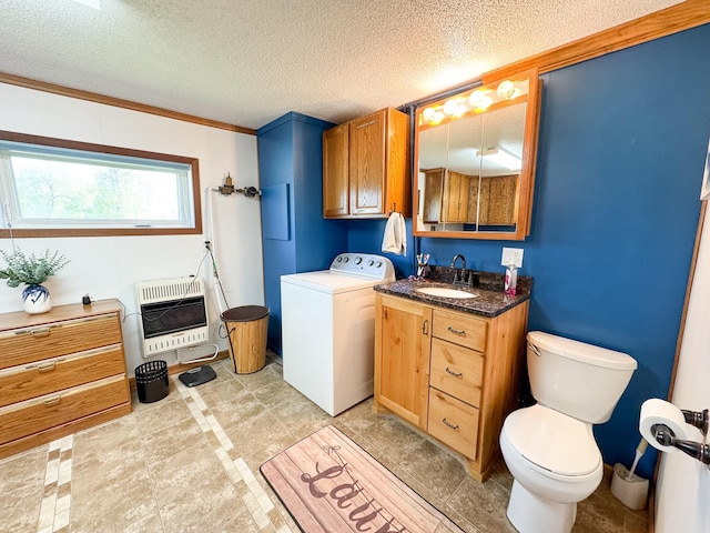 bathroom featuring heating unit, washer / clothes dryer, toilet, vanity, and a textured ceiling