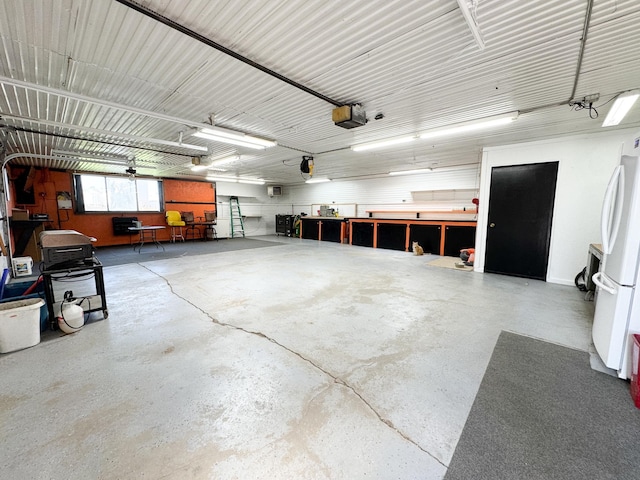 garage featuring freestanding refrigerator and a garage door opener