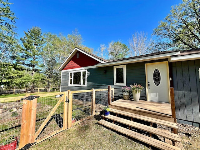view of front of property featuring fence, a deck, and a gate
