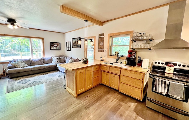 kitchen with stainless steel electric range, a sink, wall chimney exhaust hood, ceiling fan, and a peninsula