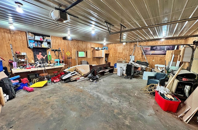 36974 320th St, Aitkin, MN 56431 - garage featuring a garage door opener, a workshop area, and wooden walls