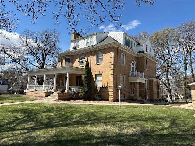 215 5th St S, Montevideo, MN 56265 - view of front facade featuring covered porch, a chimney, a front lawn, and brick siding