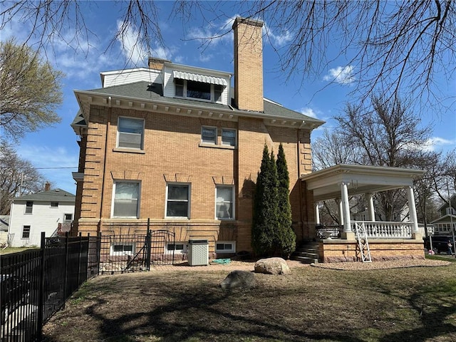 215 5th St S, Montevideo, MN 56265 - rear view of house featuring brick siding, a porch, a chimney, and central AC