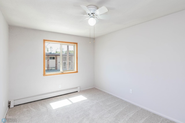 carpeted spare room with a baseboard radiator, ceiling fan, and baseboards