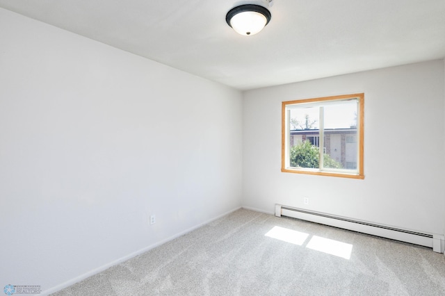 spare room with a baseboard heating unit, carpet flooring, and baseboards