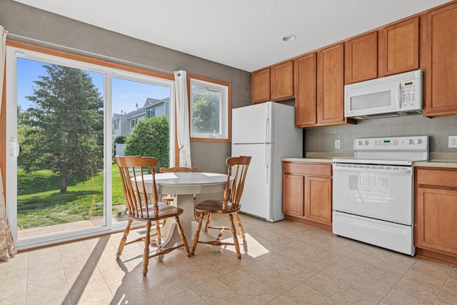 4947 Emmit Dr N Unit 4, Hugo, MN 55038 - kitchen featuring white appliances, brown cabinetry, light countertops, and recessed lighting