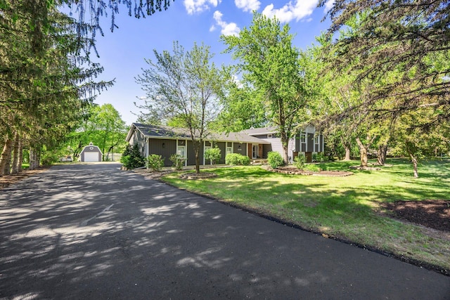 view of front of house with an outbuilding, a front yard, and a detached garage