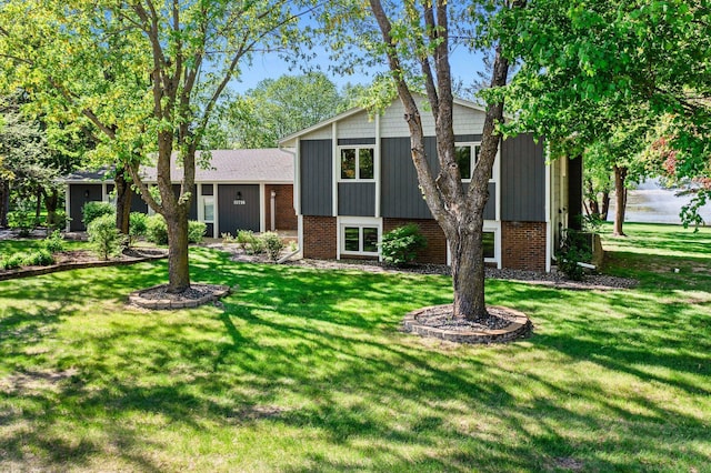 tri-level home with a front yard and brick siding