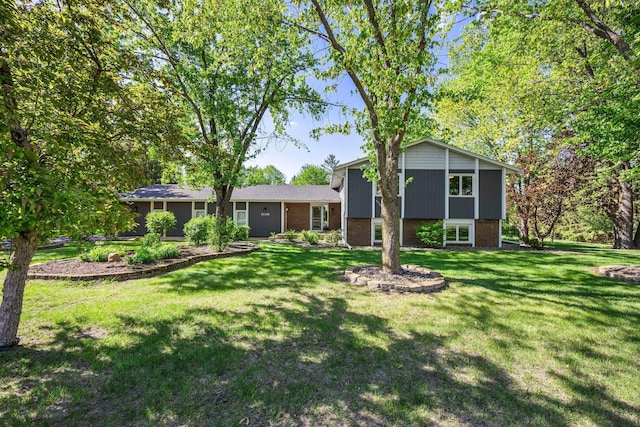 split level home with a front yard and brick siding